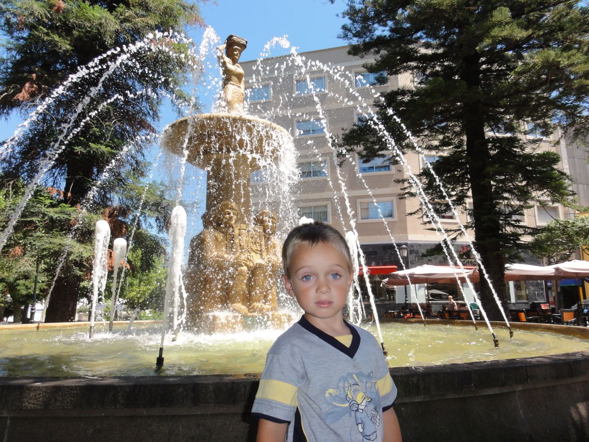 l'eau d'une fontaine en suspension derrière le regard sublime d'un petit garçon bien heureux