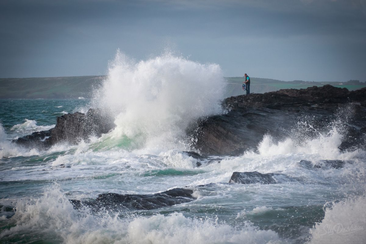 Un homme s'approche trop près des vagues et sera happé par la vague à la tête de chien. Hook Head, Ireland